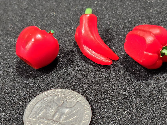 Miniature plastic peppers and tomatoes, for board games and dollhouses.
